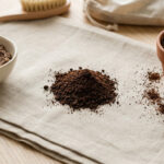 Préparations à base de marc de café : un gommage pour le corps, une pile de poudre et une plante en pot sur une serviette en lin.